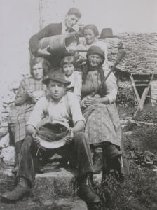 Gruppo di persone all'alpe con attrezzi della lavorazione del latte